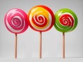 Three multicolored round lollipop on a gray background