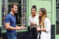 Three multiethnic people talking and smiling outdoors with smart phone in their hands. Multiracial group of friends in urban Royalty Free Stock Photo