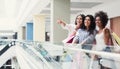 Three multiracial girls pointing at something in mall Royalty Free Stock Photo