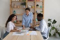 Three multiracial teammates work together on sales stats analysis Royalty Free Stock Photo