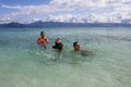 Three Muslim friends are enjoying their holidays by swimming in clear, white sand in the sunny summer