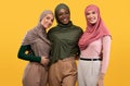 Three Muslim Ladies In Hijab Headscarf Standing Over Yellow Background Royalty Free Stock Photo