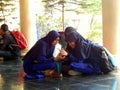 Three Muslim student girls are sitting on the floor and watching a handphone Royalty Free Stock Photo