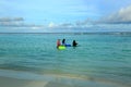 Three muslim women in colorful clothes are standing in water and going swimming. Turquoise water of Indian Ocean, Maldives.