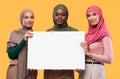 Three Muslim Women Holding Blank Board For Text, Yellow Background Royalty Free Stock Photo