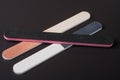 Three nail file with a different abrasive on dark background