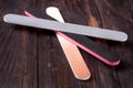 Three nail file with a different abrasive on dark wooden background