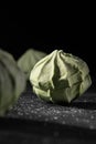 Three natural green marshmallows on a black background.