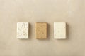 Three natural soap bars - lavender, cotton, patchouli - on natural stone background, flat lay