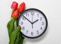 Three natural tulips flowers and clock on white background - time, love and holiday concept Royalty Free Stock Photo