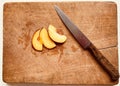 Three nectarine slices and kitchen knife. Royalty Free Stock Photo