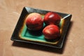 Three nectarines on a designer plate Royalty Free Stock Photo