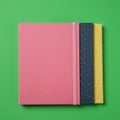 Three notebooks arranged on a green background. The top notebook features a pink Royalty Free Stock Photo