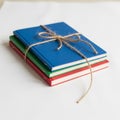 Three notebooks stacked on a white surface, each with a solid color cover: blue on Royalty Free Stock Photo