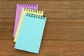 Three notepads on weathered wood desk