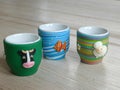 Three novelty eggcups on a wooden table