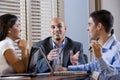 Three office workers conversing at desk