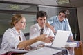 Three office workers working in boardroom