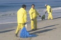 Three oil cleanup workers cleaning up the beach