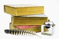 Three old books, inkstand and pen isolated on a white background