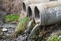 Three old concrete sewer pipes with flowing water Royalty Free Stock Photo