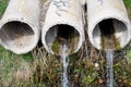 Three old concrete sewer pipes with flowing water Royalty Free Stock Photo