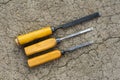 Three old different chisels lying on cracked asphalt Royalty Free Stock Photo