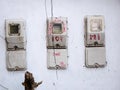 three old electrical meters installed on a white wall Royalty Free Stock Photo
