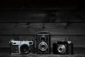 Three film cameras on a dark wooden background