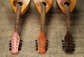 Three old mandolins rotated fingerboards to the camera on a background of rough burlap Royalty Free Stock Photo