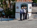 Three old men wearing face masks walking with their canes in front of the mechanical theatre in Frigiliana, Spain