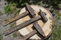 Three old metal rusty hammers lie on a wooden stump Royalty Free Stock Photo