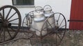 Handdrawncart with milk churns on display in farmhouse yard in southern Denmark Royalty Free Stock Photo