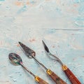 Three old palette knifes on artist canvas Royalty Free Stock Photo