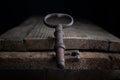 Three old rusty keys stand on old wooden board against a dark background Royalty Free Stock Photo