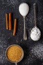 Three old spoons with brown, white, icing sugar and cinnamon sticks Royalty Free Stock Photo