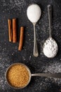 Three old spoons with brown, white, icing sugar and cinnamon sticks Royalty Free Stock Photo