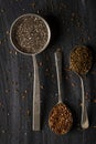 Three old spoons with chia caraway seeds and linseed on black background Royalty Free Stock Photo