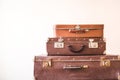 Three old vintage suitcases against a light wall background. Rustic Retro Style Royalty Free Stock Photo