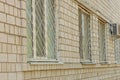 Three old white windows behind an iron grate Royalty Free Stock Photo