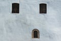 Three old windows on ancient white wall. Windows in rectangular and oval frames Royalty Free Stock Photo