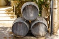 Three old wooden barrels for cognac, brandy or wine stand on the street near the house. Royalty Free Stock Photo