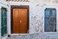 Three old wooden doors in different colors. White stone wall. Traditional village of Pyrgos on Santorini island, Greece. Royalty Free Stock Photo