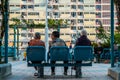Three older women on bench from behind, old people sitting on bench
