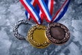 Three Olympic medals laying on the snow. Generative AI. Royalty Free Stock Photo