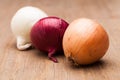 Three onions on wooden table Royalty Free Stock Photo