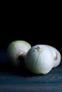 Three onions on a wooden table Royalty Free Stock Photo