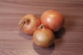 Three onions on a wooden table Royalty Free Stock Photo