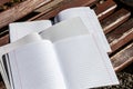 Three open notebooks in a ruler on a wooden bench