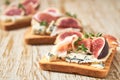 Three open sandwich with blue cheese, prosciutto and fresh figs  on a white wooden table, horizontal composition Royalty Free Stock Photo